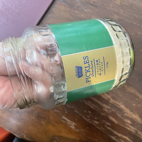 An empty pickle jar with a wide opening. A hand fits inside the jar, making it easy to wash.