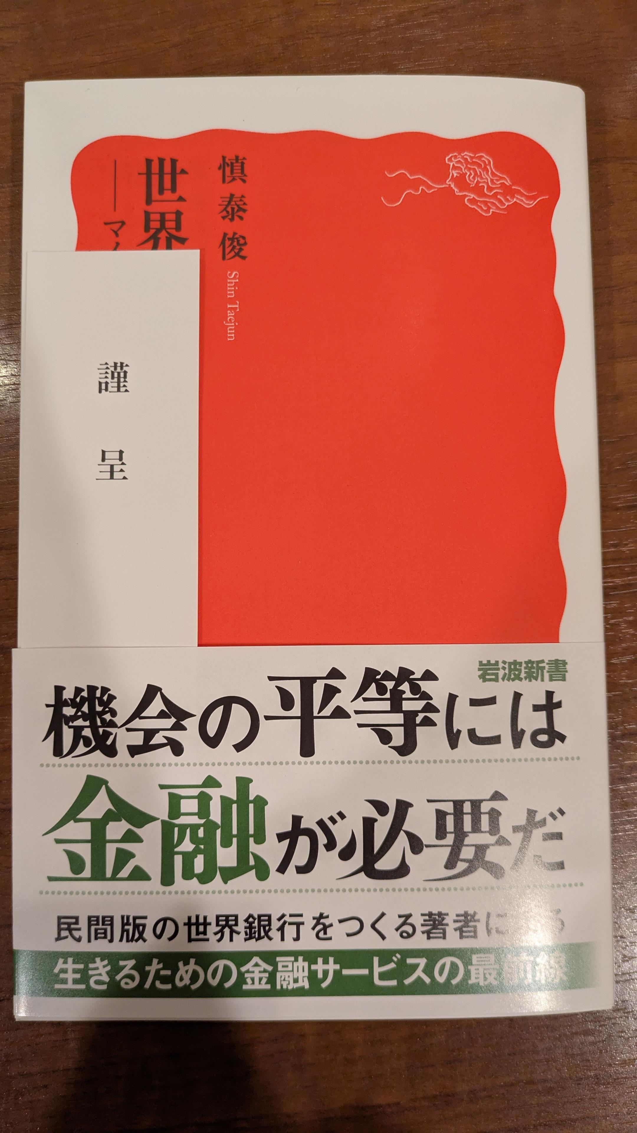 慎泰俊『世界の貧困に挑む』の書影。「謹呈」の帯が挟まれている。