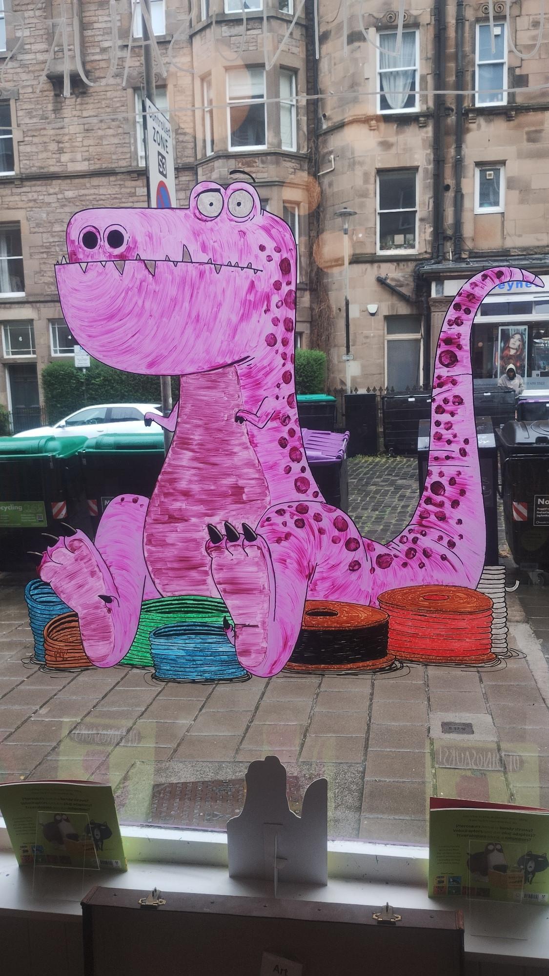The finished purple dinosaur on the window glass, viewed from the inside, looking out